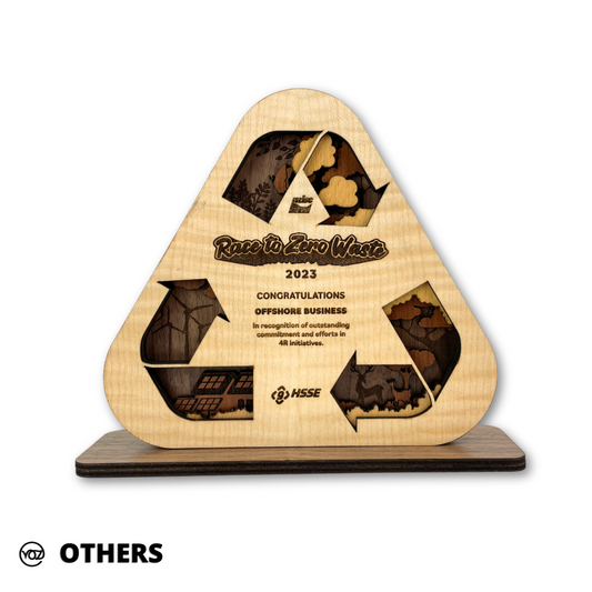 A wooden trophy with a triangular shape featuring cut-out sections revealing a layered structure, with engraved text and logos.